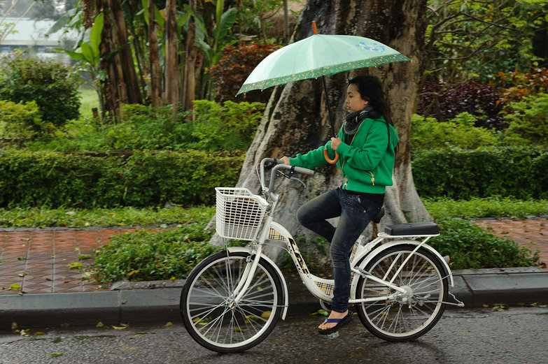 Huế Cyclist with Umbrella